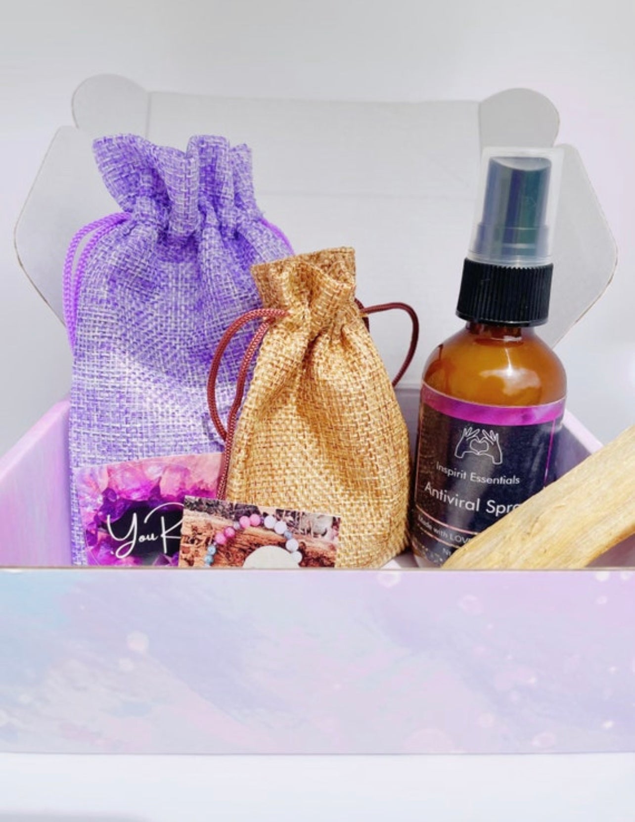 Wellness Box in lavender with essential oils spray, crystals, palo santo and stickers.